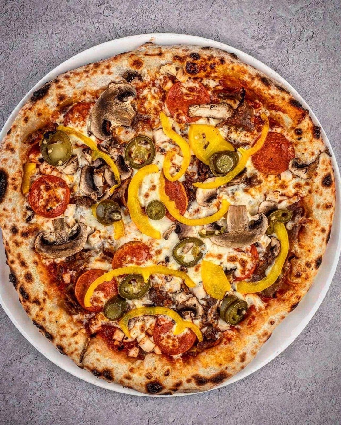 Bambinon pizza ylhäältä kuvattuna: pepperonia, herkkusieniä, jalapenoa ja paprikaa